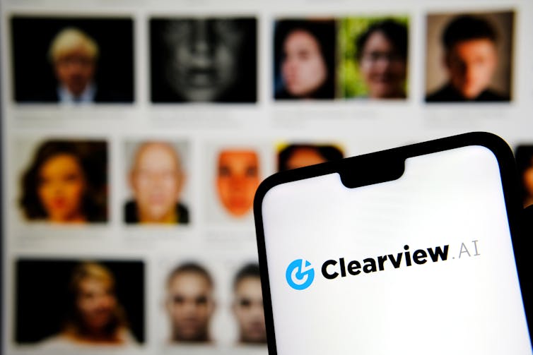 Clearview AI logo seen in front of a screen of blurred faces