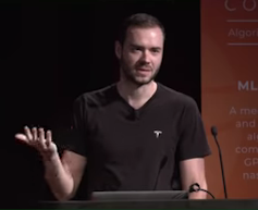 A man speaks at a lectern.