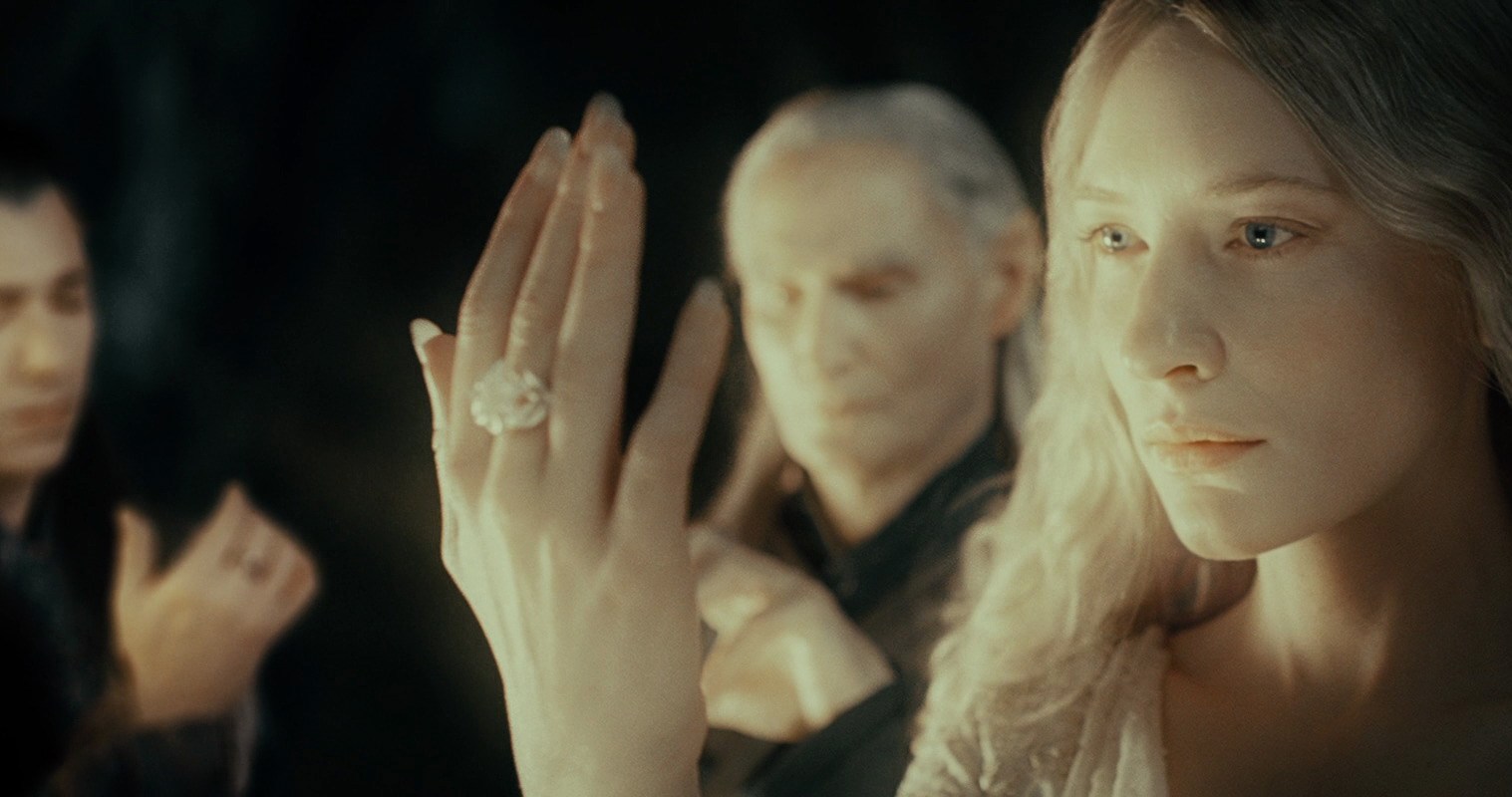 Galadriel displays her elven ring, worn on the middle finger of her white hand, in The Fellowship of the Ring.