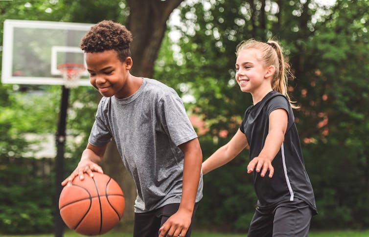 Boy and girl playing basketball