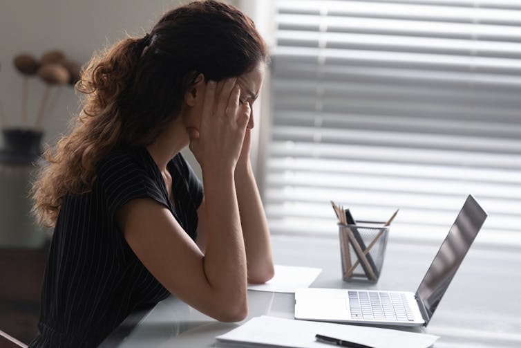 Woman struggling with a laptop