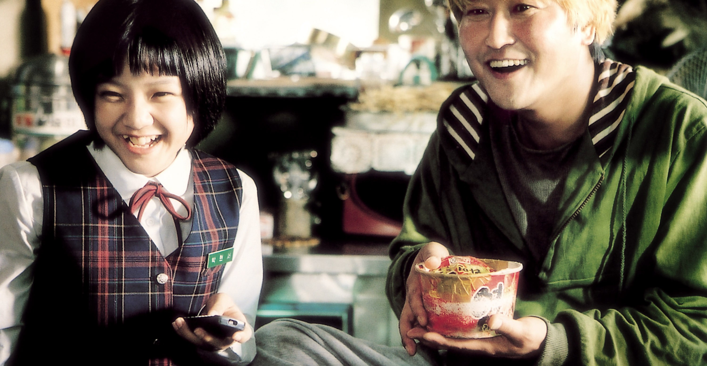 Ko Ah-sung sits next to Song Kang-ho, who is eating instant ramen in The HostKo Ah-sung sits next to Song Kang-ho, who is eating instant ramen in The Host