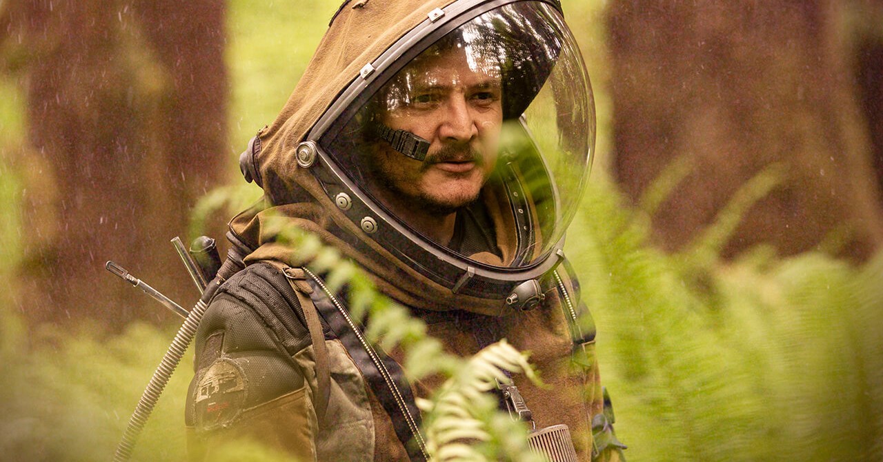 Pedro Pascal walks through the woods with a spacesuit on in Prospect