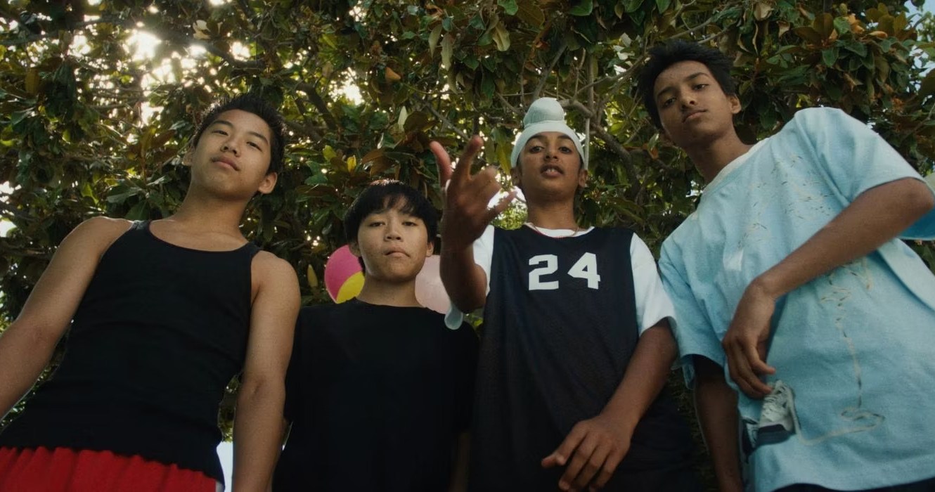 A high angle shot of  group of kids posing in front of a camera in Dìdi.