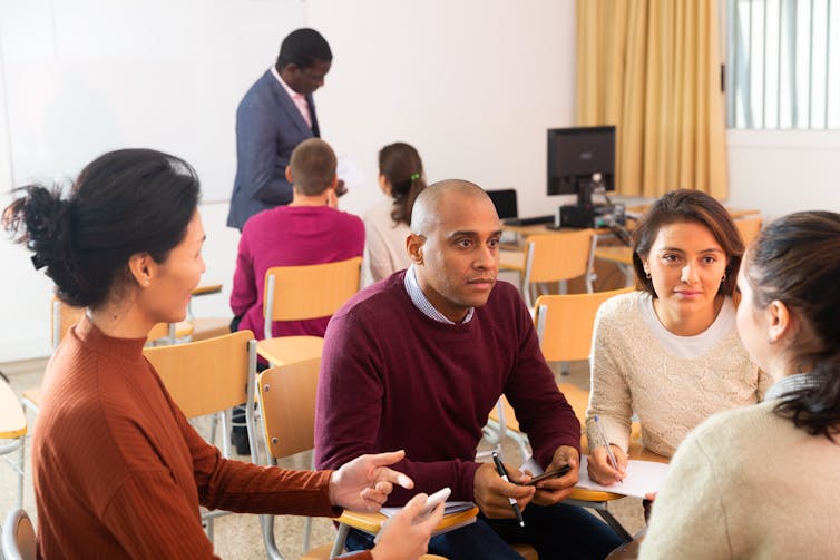 Adults in a room in discussion.