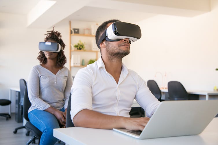 Two people indoors wearing VR headsets