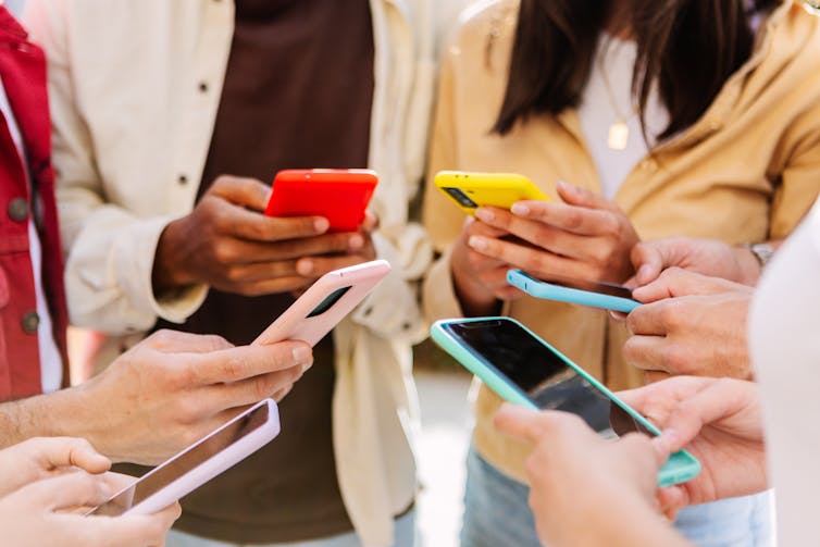 Teen hands holding phones.