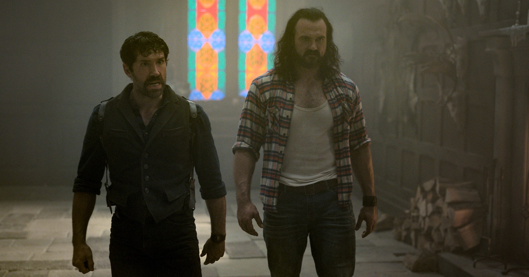 Scott Adkins and Drew McIntyre as the Mackenzie Brothers in The Killer’s Game, walking in a castle