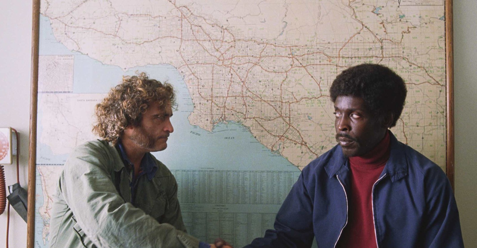 Joaquin Phoenix and Michael K. Williams
shaking hands in front of a map of Los Angeles in Inherent Vice.