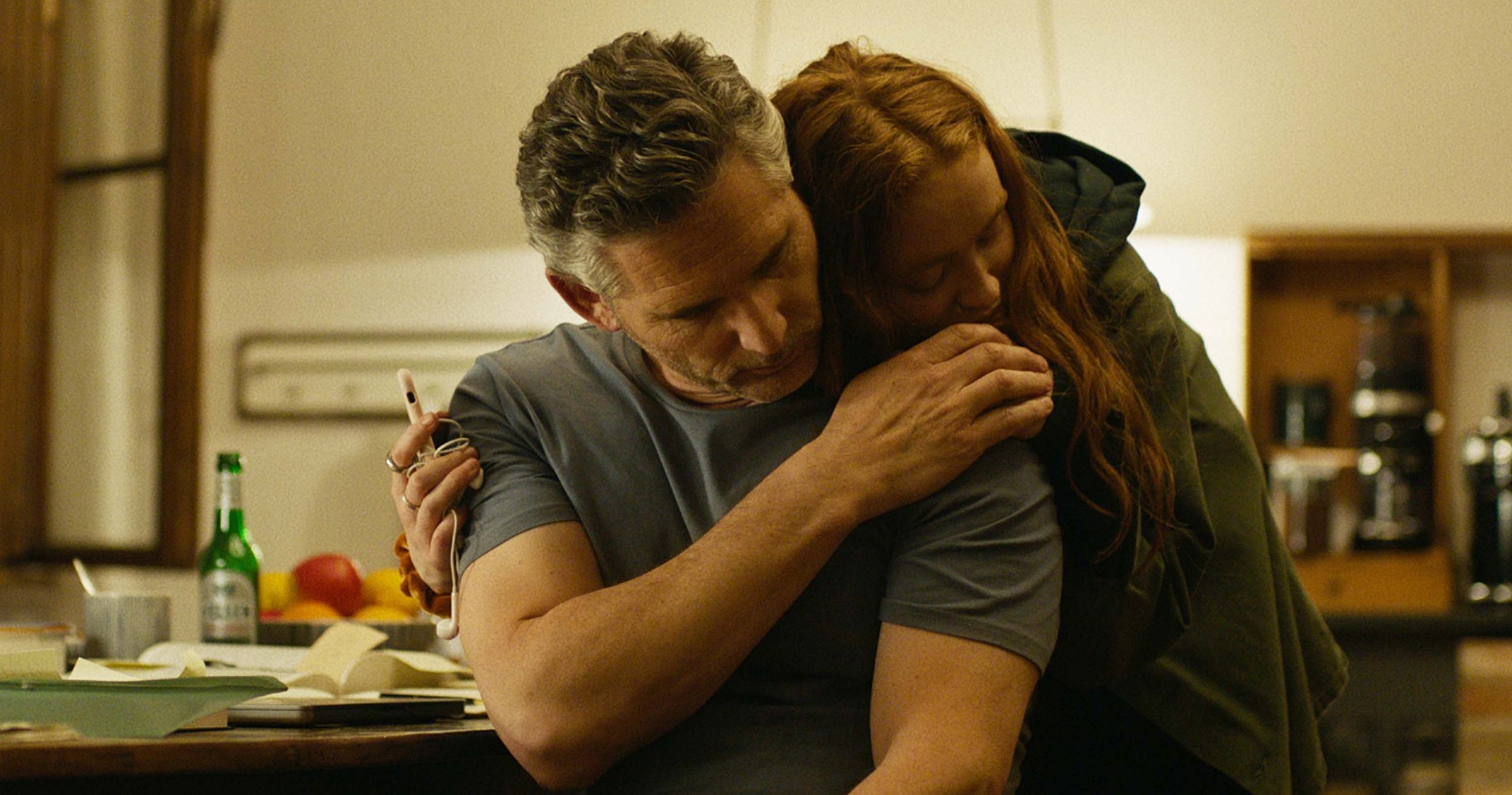 A man (Eric Bana) being consoled by a young girl (Sadie Sink) in A Sacrifice.