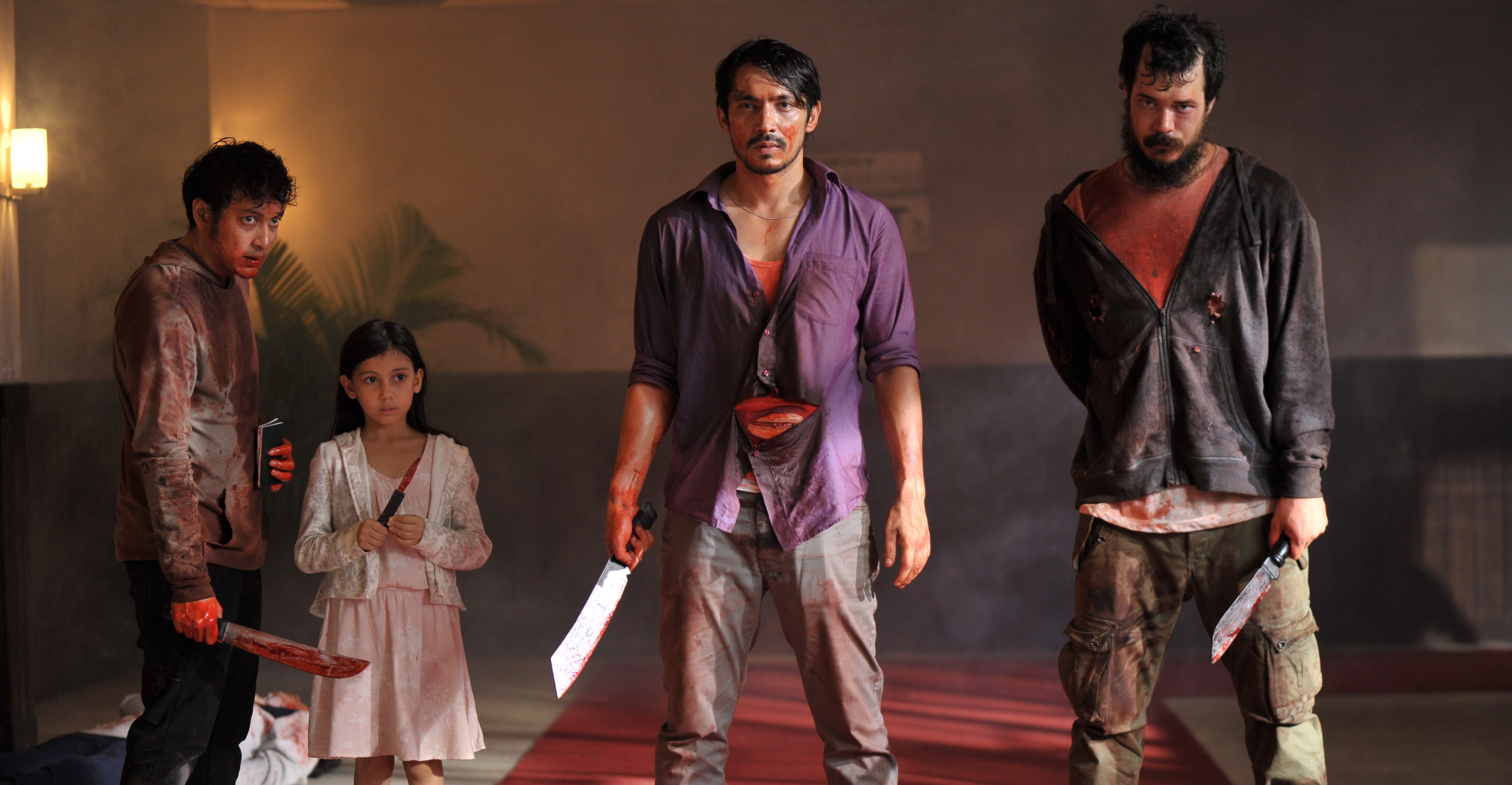 In The Night Comes For Us, three bloody men (and one small girl) hold bloody knives and look towards the camera